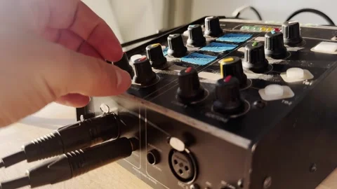 Close-up of a hand adjusting a comms knob on a broadcast intercom unit, with Stockbeeldmateriaal 336312430