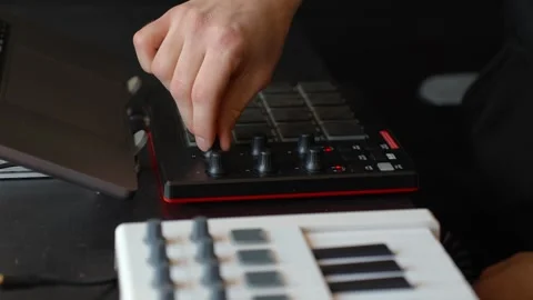 Close-up of a hand adjusting knobs on an FX controller with keyboard in 스톡 동영상 323778181