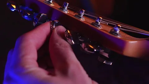 Close up of Hand Adjusting the Peg of Guitar Stock Footage 123857782