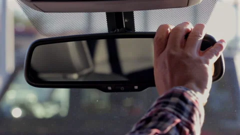 Close-up of a hand adjusting the rearview mirror inside a car, with the win.. Vídeos de archivo 285955886