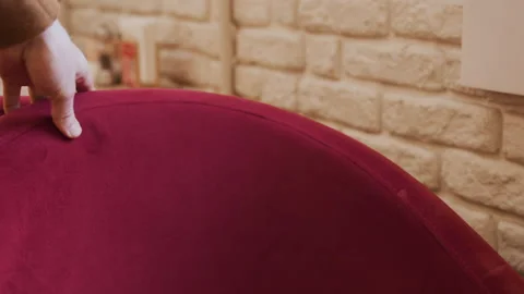 Close up of hand adjusting red upholstered chair backrest with visible stitching Stock Footage 344866805