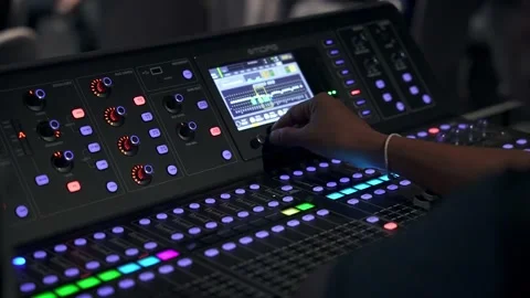 Close-up of a hand adjusting settings on a modern audio mixer with glowing Stock Footage 274696986