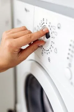 Close-up of a hand adjusting the settings on a modern washing machine contr.. 스톡 사진