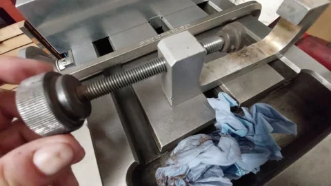 Close-up of a hand adjusting a threaded rod on a heavy-duty industrial clamp fix Stock Footage 335826688