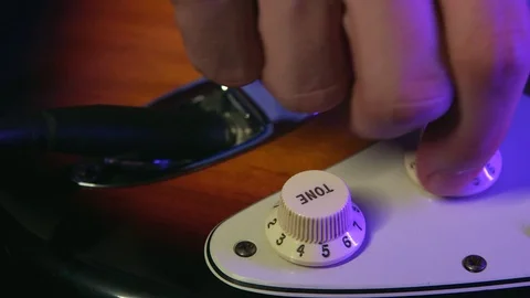 Close up of Hand Adjusting Tone Button of Guitar Stock Footage 124086901