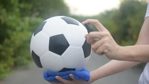 Close up hand Alcohol spray cleaning Football are New normal and Football League Stock Footage 130509364