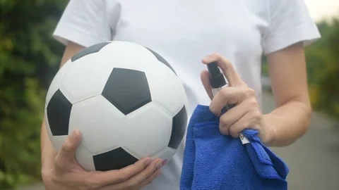 Close up hand Alcohol spray cleaning Football are New normal and Football League Stock Footage 130509368