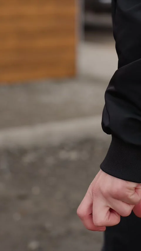Close up of hand and arm in black clothing with blue zipper pulls moving through Stock Footage 345547516