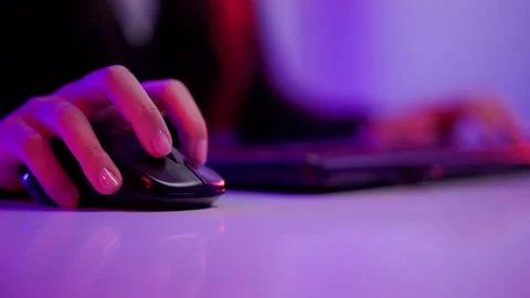 Close-up hand and mouse playing games. Young woman sitting on chair. Stock Footage 175694134