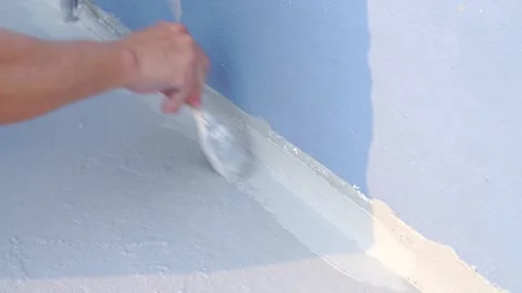 Close-up of a hand applying grey waterproof sealant or paint with a brush t.. Stock Footage 331280492
