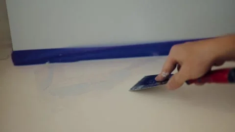 Close up of hand applying plaster paste on wall with spatula during repair work. Stock Footage 342515019