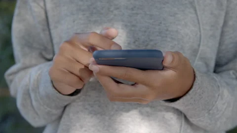 Close up of hand are using smartphone while standing in park public outdoor Stock Footage 139898024