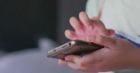 Close-up hand Asian child playing with a smartphone and sitting in bed  fro.. Stock Footage 259778954