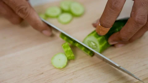 Close-up hand of Asian man using a knife to thinly slice cucumbers. Stock Footage 240641539