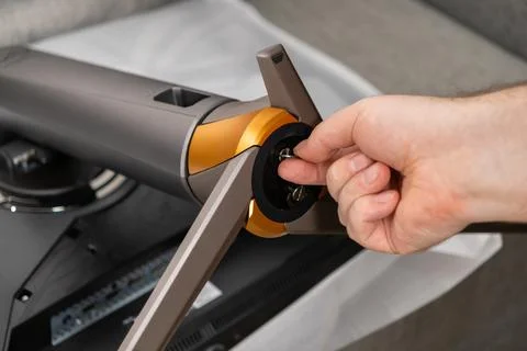 Close-up of a hand attaching a modern computer monitor stand with stylish g.. Stock Photos