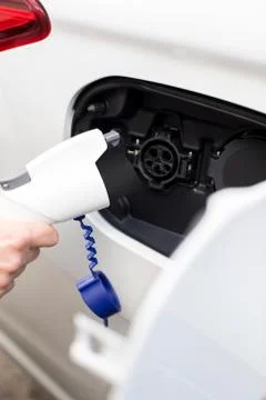 Close Up Of Hand Attaching Power Cable To Environmentally Friendly Zero Emiss Stock Photos