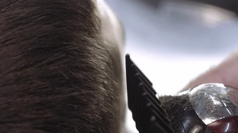 Close-up of the hand of a barber cutting a man's client's hair Stock Footage 112334202