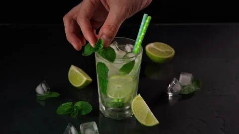 A close-up of the Hand of a bartender Decorating a Sprig of Mint Mojito Cocktail Stock Footage 237436389