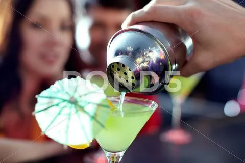 Close-up of hand of bartender pouring cocktail into martini glass Stock Photos