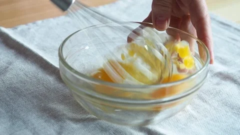 Close-up of a hand beating eggs in a glass bowl Stock Footage 262217640