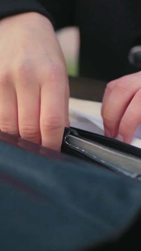 Close Up of Hand in Black Clothing Retrieving Diary from Bag with Light Effect Stock Footage 310814331
