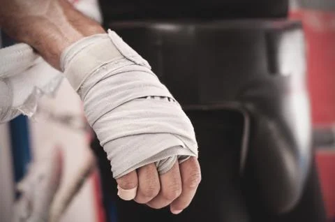 Close up of hand of boxer leaning on ropes on a boxing ring. Stock Photos