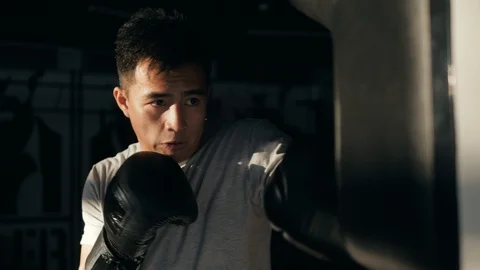 Close-up hand of boxer at the moment of impact on punching bag asian korean Stock Footage 100587371