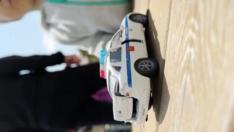Close up of the Hand of the boy taking toy police car. 14 June 2023. Russia Stock Footage 244491515