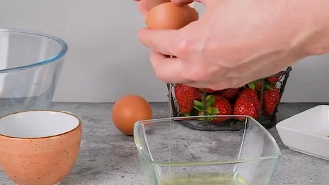 Close up hand breaking an egg to the bowl.  Stock Footage 256606490