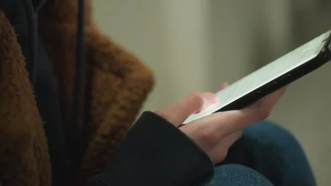 Close-Up of a Hand in Brown Coat Scrolling Through Smartphone Video stock 283167128