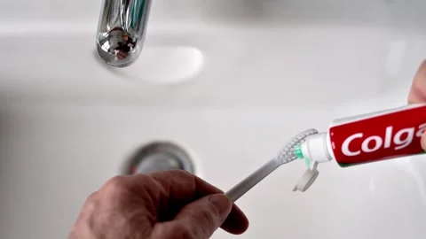 Close-Up Of Hand Brushing Teeth With Toothpaste At Bathroom Sink Stock Footage 325418352