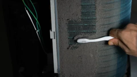 Close-up of a hand brushing thick dust from an air conditioner filter or co.. Vídeo Stock 338319393