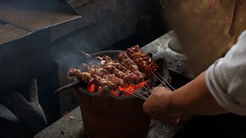 Close up hand burning lamb satay or sate klatak on traditional stove Stock Footage 119917000