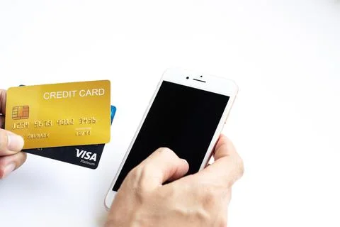 Close up hand of business man using a credit card and mobile smartphone Stock Photos