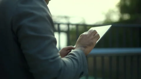  Close up hand of businessman using tablet through a cityscape with towering. Video stock 243252304