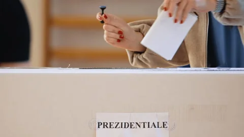 Close-up of a hand casting a vote into the ballot box Stock Footage 320962636