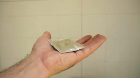 Close-up of a hand catching a condom in motion Stock Footage 311760208