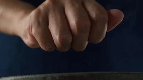 Close up. Hand of chef is sprinkling black peppercorns in stone mortar Stock Footage 120214006