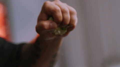 Close up hand chef squeezing a lime in slow motion with shallow focus and Stock Footage 100306825