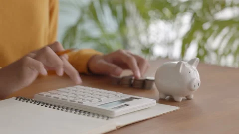 Close-up of hand child is press the calculator and count coins Stock Footage 153973645