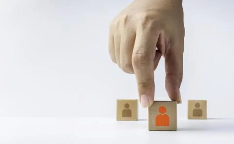 Close-up hand choosing the one of a red human or people icon on wooden cube b Stock Photos