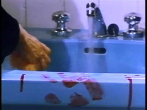 Close-up of hand cleaning blood stained sink with sponge Stock Footage 260251012