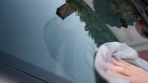 Close-up of a hand cleaning a car windshield with a microfiber cloth Stock Footage 340630129