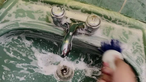 Close up of hand cleaning kitchen sink with sponge and soapy water during Stock Footage 343711706