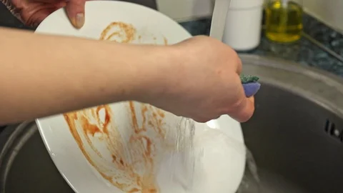 Close-up Of Hand Cleaning Plate With Scrubber Stock Footage 128604331
