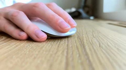 Close-up of a hand clicking a mouse on desk. Fingers navigating cursor duri.. Stockbeeldmateriaal 342540646