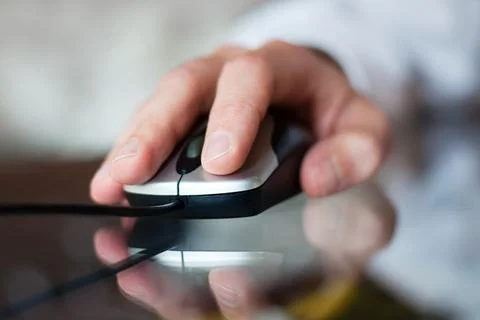 Close up of hand with computer mouse on blurred background Stock Photos