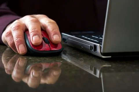 Close up of hand on a computer mouse with lap top computer Foto stock