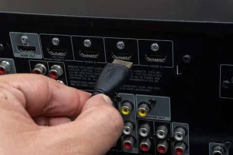 Close-up of hand connecting HDMI cable to home theater device Stock Photos