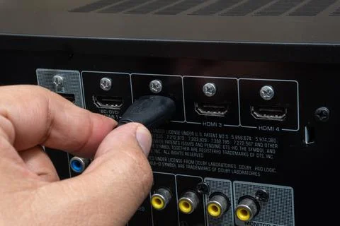 Close-up of hand connecting HDMI cable to home theater device Stock Photos